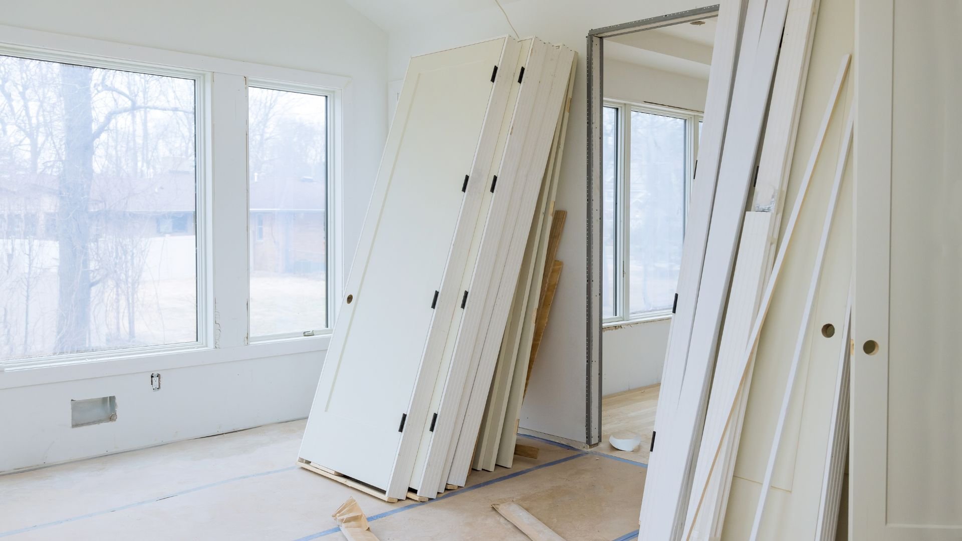 Interior home renovation with white doors and windows in unfinished room