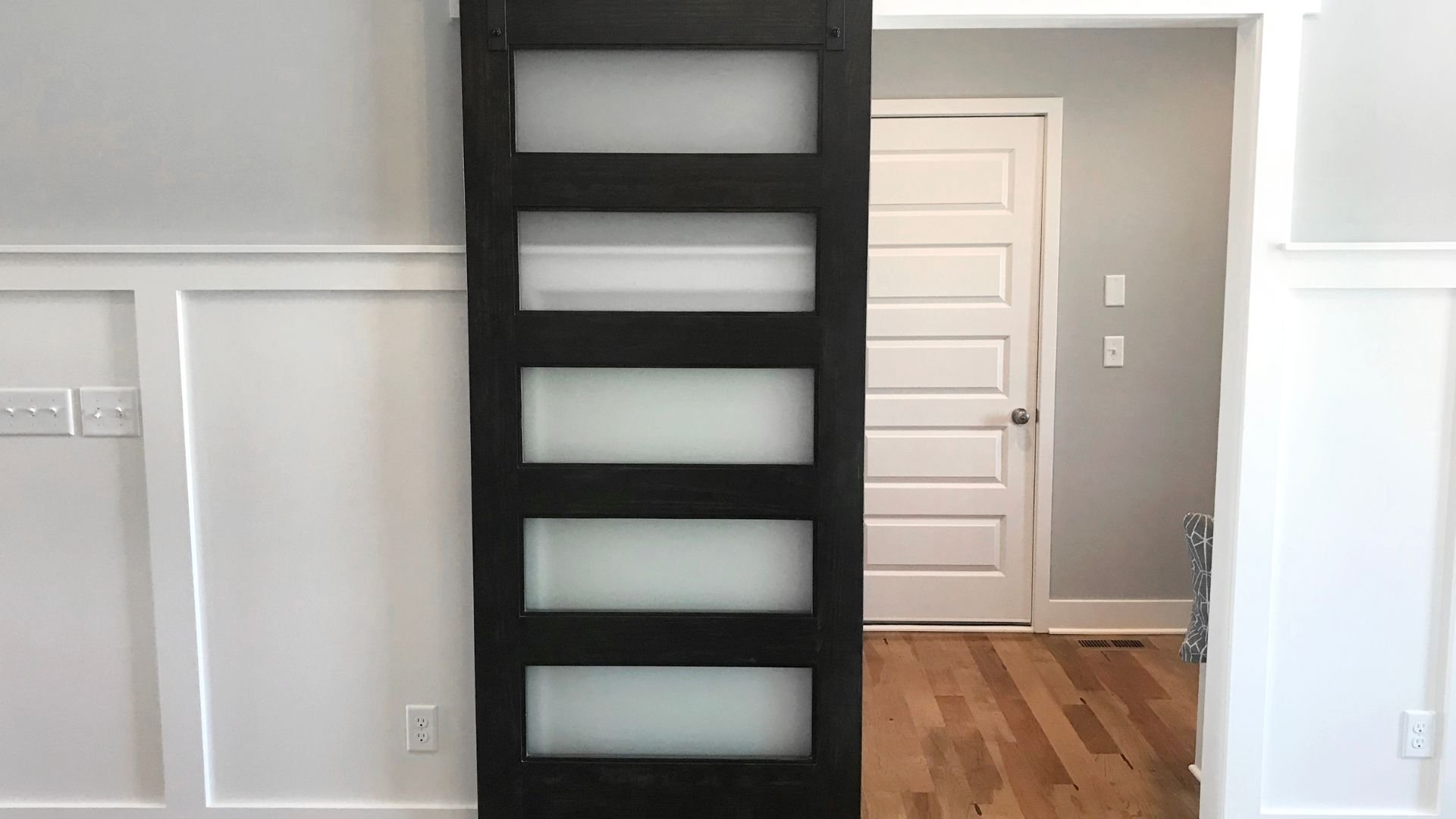 Black modern door with frosted glass panels in minimalist interior